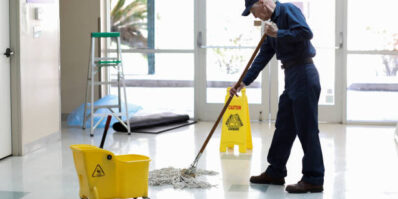Senior adult Janitor keeps the floors cleaned and sanitized due to the virus.